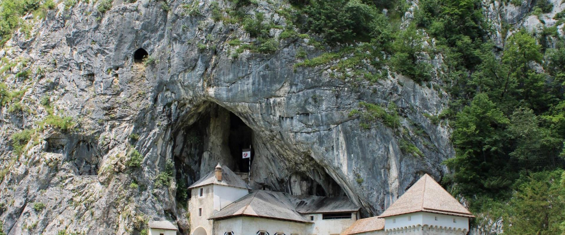 Free Explore the historic Predjama Castle built into the cliffs of Slovenia, surrounded by lush nature. Stock Photo