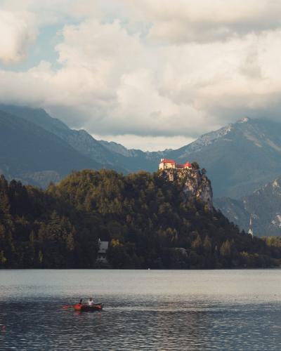Picturesque Bled Castle overlooking serene Lake Bled, framed by majestic mountains.